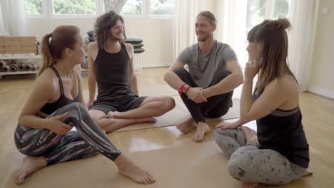 Fröhliche-Yoga-Gruppe,-Die-Drinnen-Zusammen-Sitzt